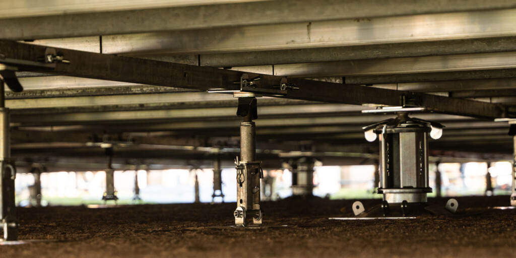 Close-up of FloorStak telescopic support columns and intermediate i-Stak units levelling a marquee floor on uneven ground.