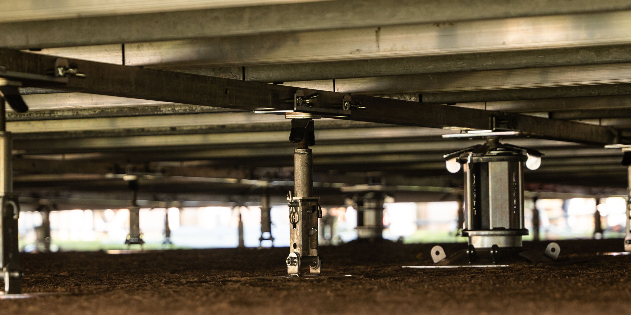 Close-up of FloorStak telescopic support columns and intermediate i-Stak units levelling a marquee floor on uneven ground.